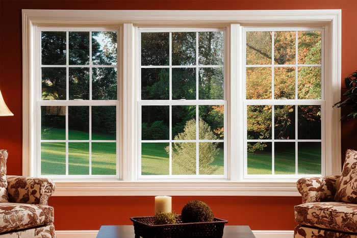 Bright interior bay window with white frames overlooking a residential city street and brick buildings, filling the room with natural light and showcasing professional Window Replacement Atlanta services for enhanced comfort and energy efficiency.