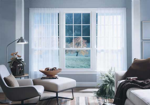 Home exterior featuring a white-framed window with curtains and indoor plants, surrounded by climbing vines on a textured wall, showcasing classic style, improved insulation, and professional Window Replacement Alpharetta services.