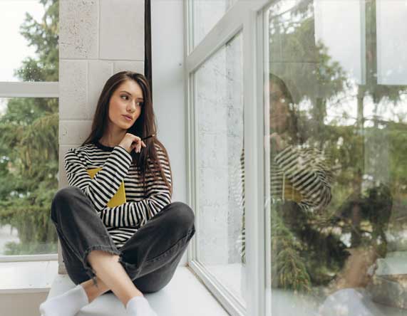 Interior view of white-framed windows overlooking trees and a river, filling the room with natural light and scenic views, showcasing modern design and professional Window Replacement Alpharetta services for improved comfort and efficiency.