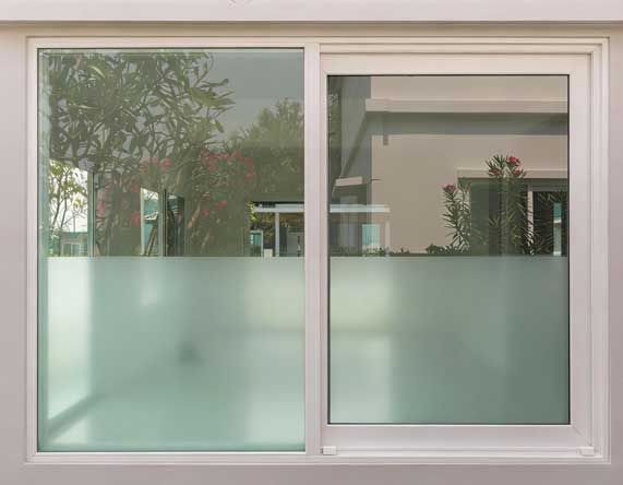 Modern home exterior featuring a white-framed sliding window with clear glass reflecting indoor and outdoor spaces, highlighting clean design, natural light, and professional Window Replacement Alpharetta services for energy-efficient living.