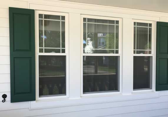 Window Replacement Dallas GA featuring newly installed white double-hung windows with green shutters on a residential home exterior, enhancing curb appeal and energy efficiency