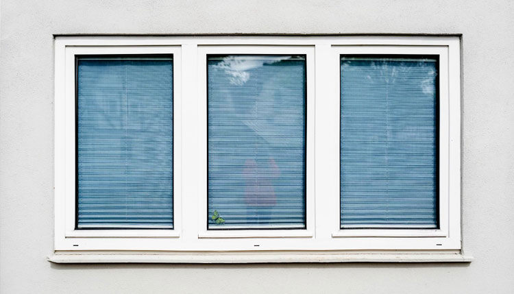 Exterior wall featuring three white-framed double hung windows with closed blinds, showcasing a clean modern façade, privacy, and professionally installed Double Hung Windows Atlanta for durability and energy efficiency.