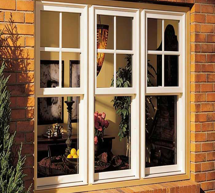 Couple sitting at a table by a large white-framed window enjoying coffee and conversation in a bright modern interior, highlighting natural light, comfort, and professional Window Replacement Atlanta services for stylish, energy-efficient spaces.