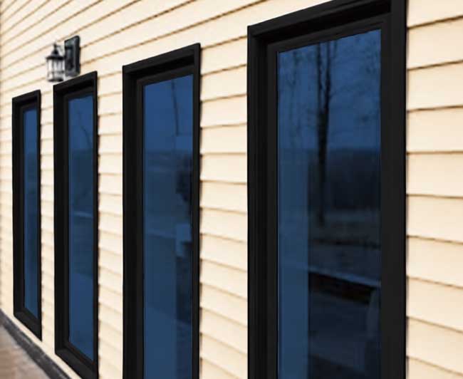 Bright interior bay window with white frames overlooking a residential city street and brick buildings, filling the room with natural light and showcasing professional Window Replacement Atlanta services for enhanced comfort and energy efficiency.