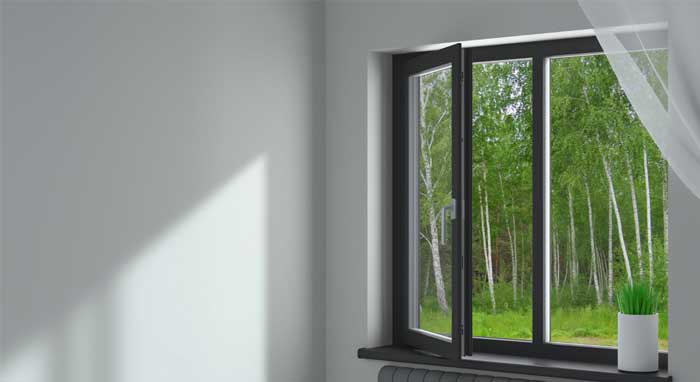 Bright interior bay window with white frames overlooking a residential city street and brick buildings, filling the room with natural light and showcasing professional Window Replacement Atlanta services for enhanced comfort and energy efficiency.