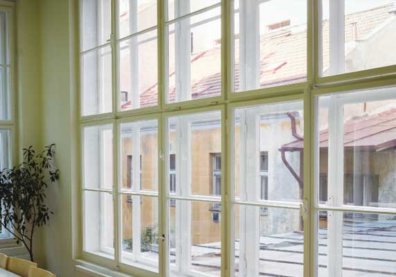 Window Replacement Woodstock featuring large white grid-style windows that allow abundant natural light and provide a clear outdoor view, enhancing interior brightness and modern home aesthetics.